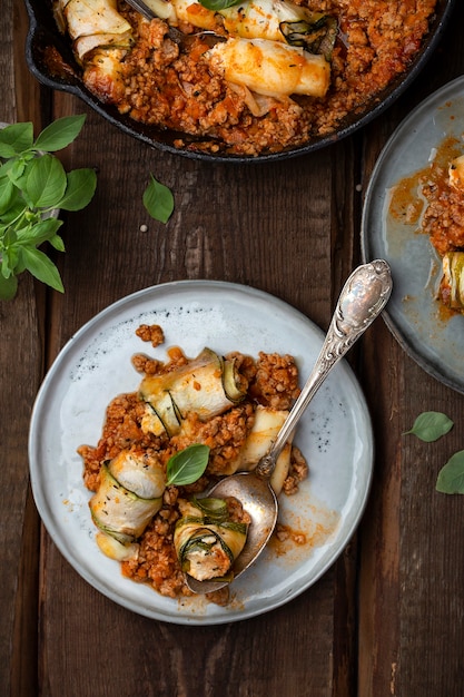 Involtini di zucchine al forno con ricotta ed erbe aromatiche in ragù di carne alla bolognese e basilico