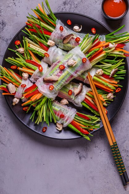 Involtini primavera con verdure e funghi shiitake su un piatto.