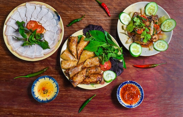 Involtini primavera vietnamiti fritti tradizionali con carne di maiale, carta di riso con salse, fette di carne e manzo st