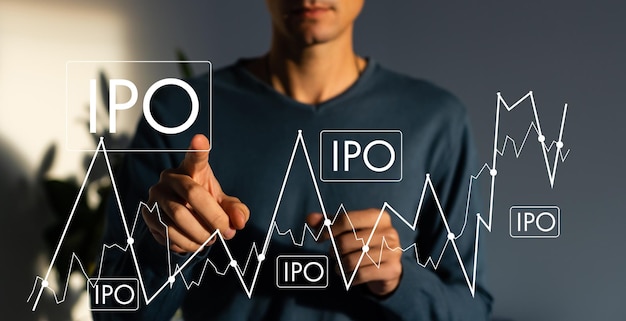 IPO - concetto di offerta pubblica iniziale con la mano che preme un pulsante su sfondo astratto sfocato.