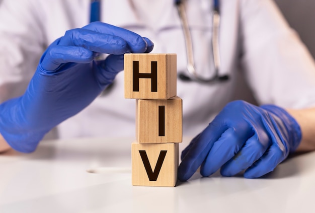 Iscrizione di acronimo di HIV sui dadi nelle mani del medico.