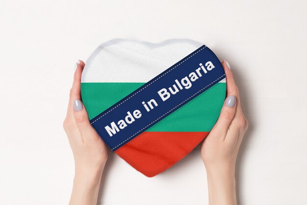 Iscrizione fatta in Bulgaria la bandiera della Bulgaria. Mani femminili che tengono una scatola a forma di cuore. .