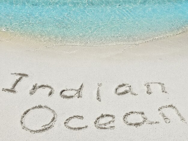Iscrizione "Ocean" nella sabbia su un'isola tropicale, Maldive.