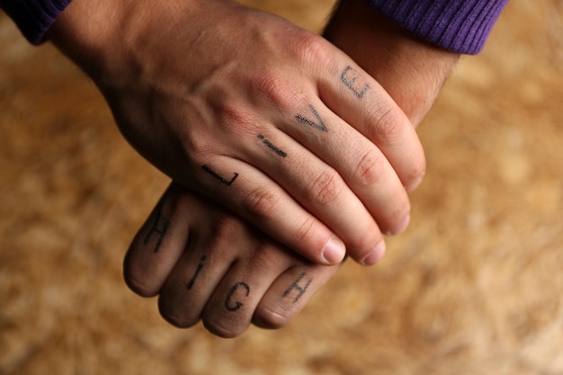 Iscrizioni del tatuaggio sulle dita maschili disegnate con pennarello