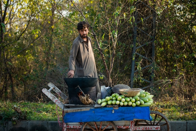 Islamabad, Islamabad Capital Territory, Pakistan - 2 febbraio 2020, Un ragazzo sta arrostendo mais fresco per i clienti.