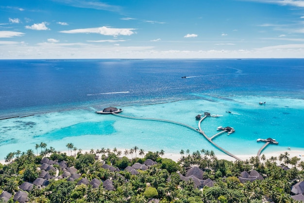 Isola paradisiaca delle Maldive. Paesaggio aereo tropicale, ville bungalow sull'acqua della baia dell'oceano, costa esotica