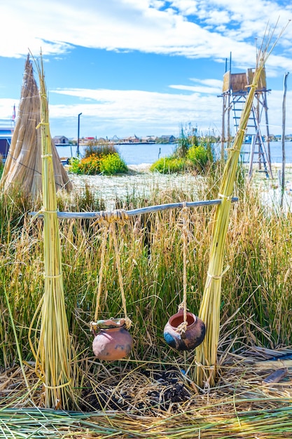 Isole galleggianti sul lago Titicaca Puno Perù Sud America casa con tetto di paglia Radice densa che le piante Khili intrecciano formano uno strato naturale di circa uno o due metri di spessore che sostiene le isole