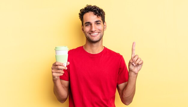 Ispanico bell'uomo sorridente e dall'aspetto amichevole, mostrando il numero uno. portare via il concetto di caffè