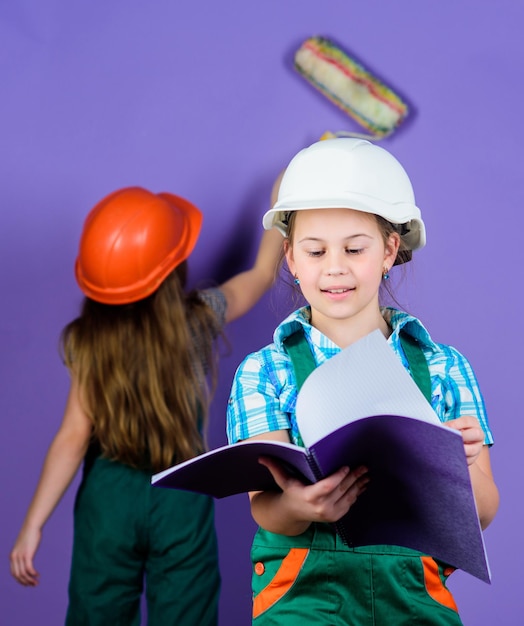 Ispettore caposquadra Idea ingegneristica di riparazione Carriera futura Ragazzini con casco con tablet e rullo Festa del lavoro 1 maggio Piccole ragazze che riparano insieme in officina Riparare è ciò che so fare bene