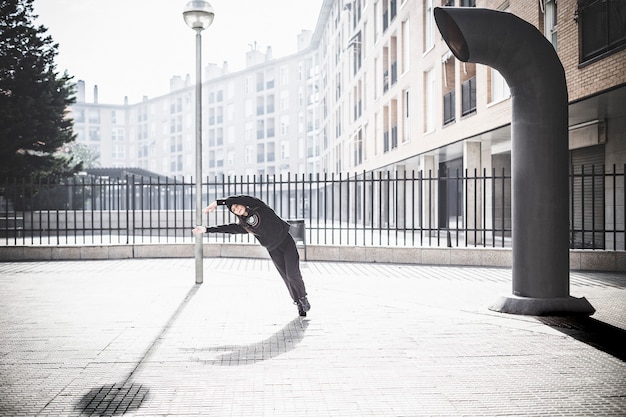 Istantanea che congela il movimento di un ballerino di danza contemporanea in un ambiente urbano