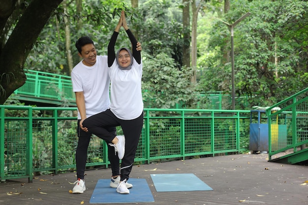 Istruttore che aiuta la donna equilibrata praticando meditare e yoga energetico.