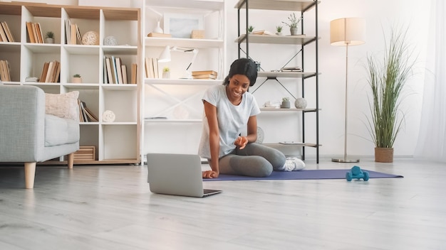 Istruttore di fitness remoto yoga online stile di vita sportivo amichevole donna snella nell'insegnamento dell'abbigliamento sportivo