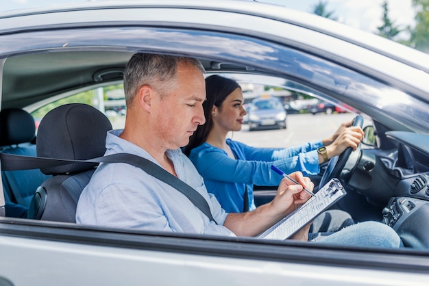 Istruttore di guida e studentessa in auto d&#39;esame