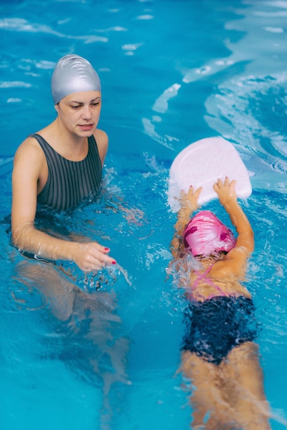 Istruttore di nuoto che lavora con una bambina