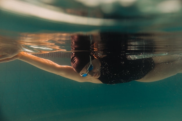 Istruttore di nuoto femminile sott'acqua