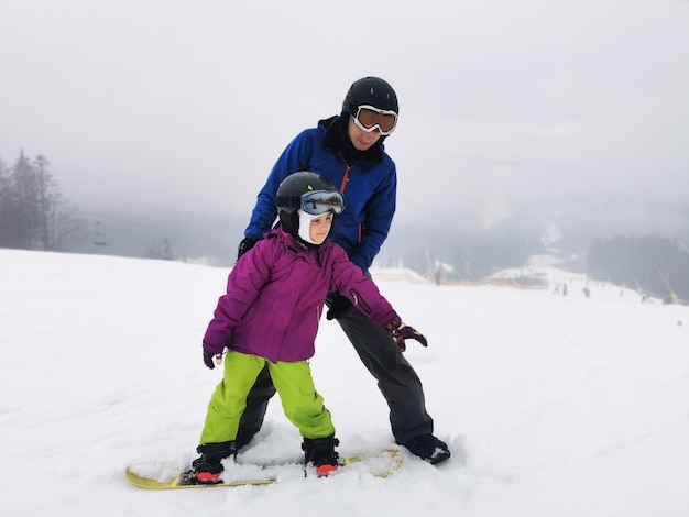 Istruttore di snowboard con bambino