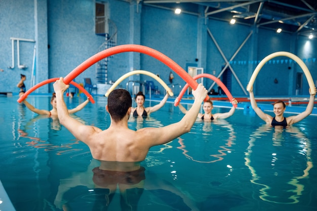 Istruttore e gruppo femminile, allenamento in piscina