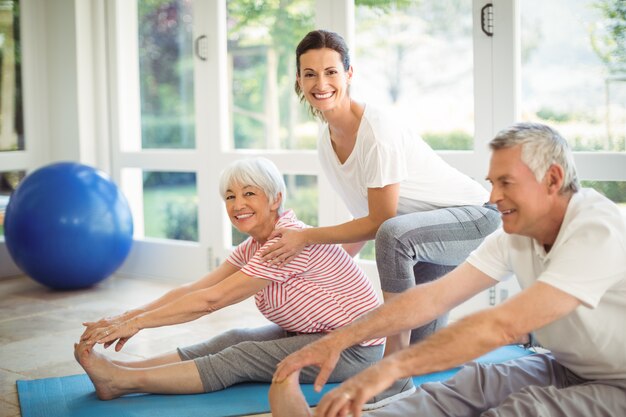 Istruttore femminile che assiste le coppie senior nell'esercizio