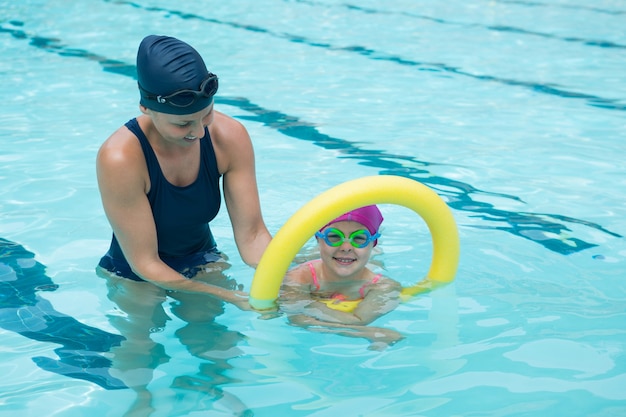 Istruttore femminile formazione giovane ragazza in piscina
