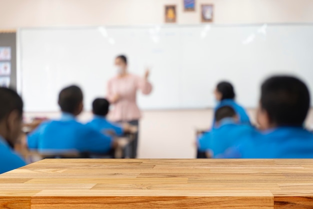 Istruttore sfocato che insegna a scuola un'insegnante donna in piedi in classe insegna agli studenti che stanno studiando e ascoltando