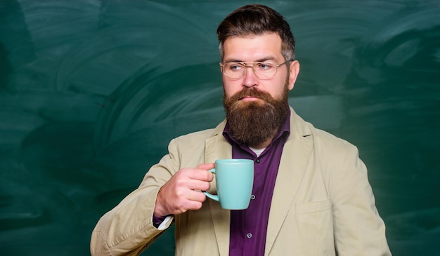 Istruzione e concetto di scuola uomo barbuto hipster bere il tè a scuola pronto per la lezione insegnante maturo alla lavagna Verso la conoscenza buongiorno caffè torna a scuola look intelligente