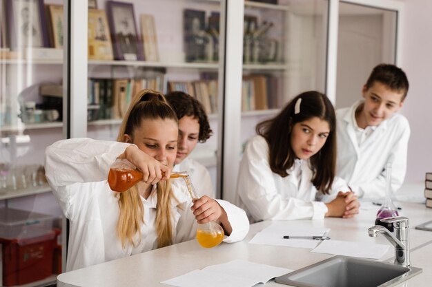 Istruzione Esperimenti chimici in una lezione di chimica a scuola Compagni di classe dei bambini che fanno esperimenti in laboratorio