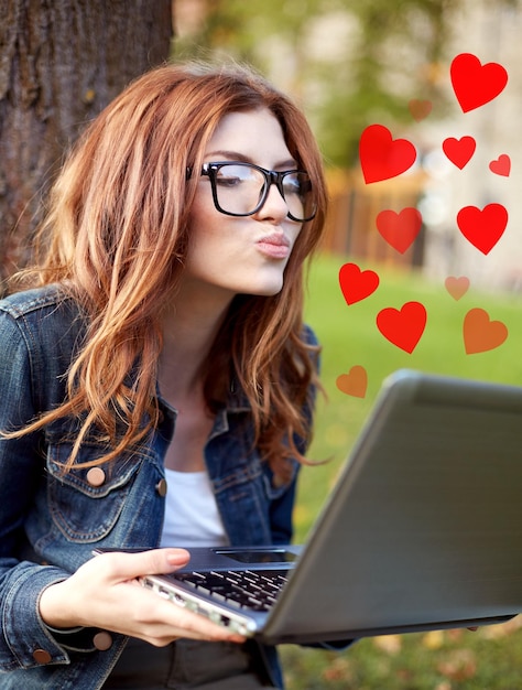 istruzione, flirt, relazione distante, comunicazione virtuale e concetto di amore - ragazza studentessa felice con un computer portatile che invia un bacio d'aria al campus