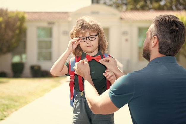 Istruzione primo giorno a scuola padre e figlio tornano da scuola valore familiare felice