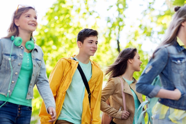 istruzione, scuola superiore, comunicazione e concetto di persone - gruppo di studenti adolescenti felici che camminano all'aperto