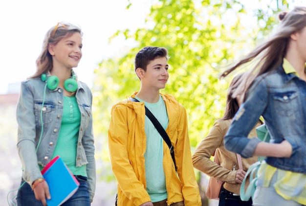 istruzione, scuola superiore, comunicazione e concetto di persone - gruppo di studenti adolescenti felici che camminano all'aperto