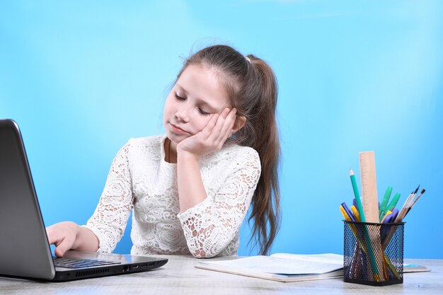 Istruzione, scuola, tecnologia e concetto di internet - piccola studentessa con pc portatile a scuola. Apprendimento a distanza in quarantena.