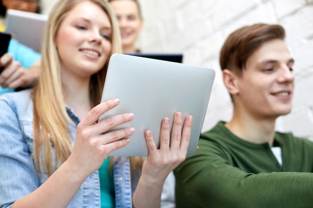 istruzione, tecnologia, persone e concetto di internet - primo piano di studenti sorridenti con computer tablet pc a scuola