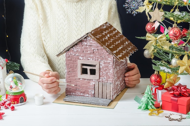 Istruzioni dettagliate per realizzare una decorazione natalizia di una casa di cartone passaggio 6 applicare la vernice bianca sui mattoni con un pennello asciutto