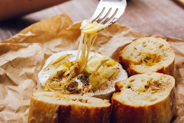 Istruzioni per il camembert al formaggio al forno fai da te passo dopo passo. degustazione di camembert. tratti di formaggio fuso.