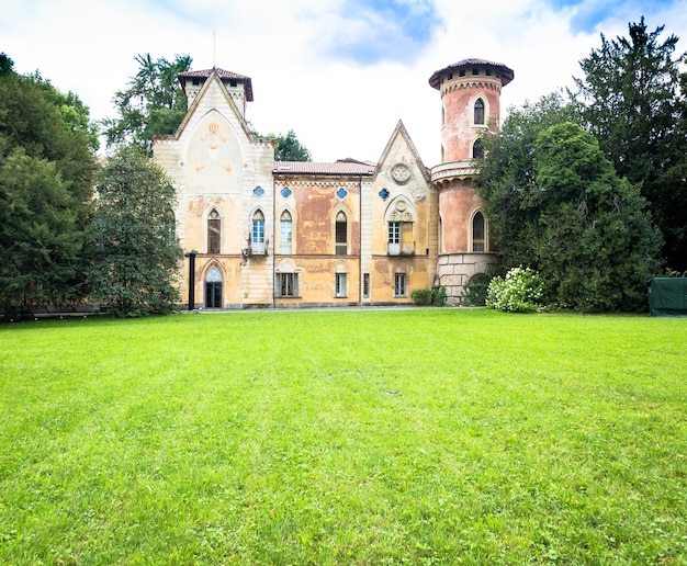 ITALIA, MIRADOLO - CIRCA AGOSTO 2020: Castello di design gotico situato in un giardino italiano, pieno di mistero, con luce del tramonto.