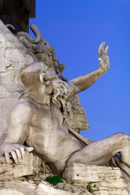 Italia Roma Piazza Navona una delle statue in marmo della Fontana dei Quattro Fiumi al tramonto Bernini 1648 aC