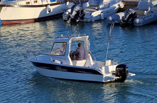 Italia, Sicilia, Mar Mediterraneo, Marina di Ragusa (provincia di Ragusa); 3 febbraio 2021, pescatori in barca a motore nel porto - EDITORIALE