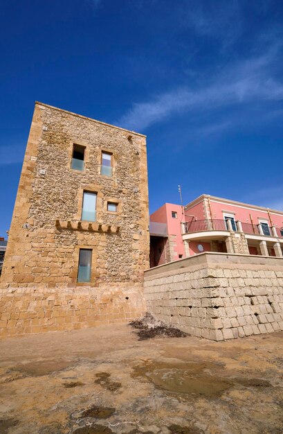 Italia Sicilia Mar Mediterraneo Punta Secca Provincia di Ragusa vista di una torre saracina ristrutturata e di un edificio barocco sul lungomare