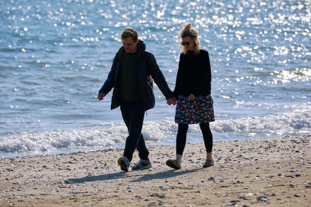 Italia, Sicilia, Playa Grande (provincia di Ragusa); 24 marzo 2022, coppia che cammina sulla spiaggia - EDITORIALE