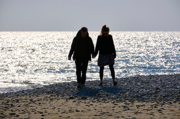 Italia, Sicilia, Playa Grande (provincia di Ragusa); coppia che cammina sulla spiaggia