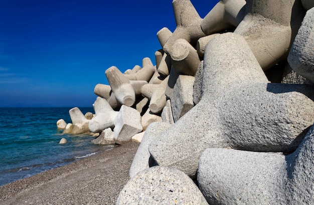 Italia, Sicilia, provincia di Messina, tetrapodi di cemento sulla spiaggia vicino a un porto in costruzione