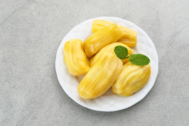 Jackfruit fresco e maturo servito su un piatto su un tavolo di legno Spazio per il testo