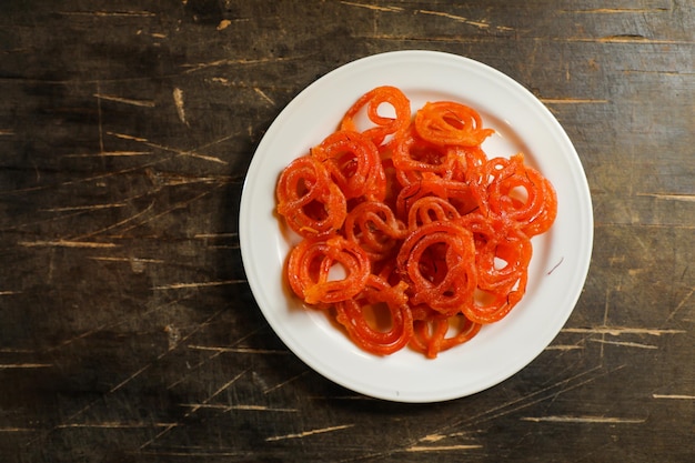 Jalebi o Jilapi serviti in un piatto isolato su tappetino vista dall'alto del bangali indiano e del dolce pakistano mithai