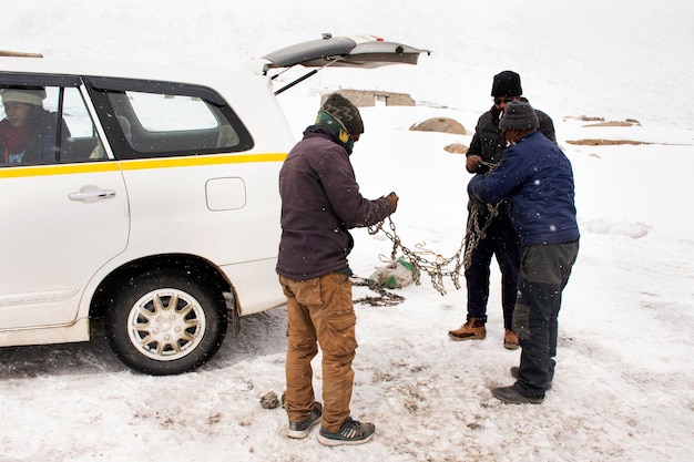 JAMMU KASHMIR INDIA MARZO 22 Gli indiani usano catene legate alle ruote dei pneumatici per proteggere lo slittamento durante la guida durante la guida su strada innevata Leh Ladakh il 22 marzo 2019 in Jammu e Kashmir India