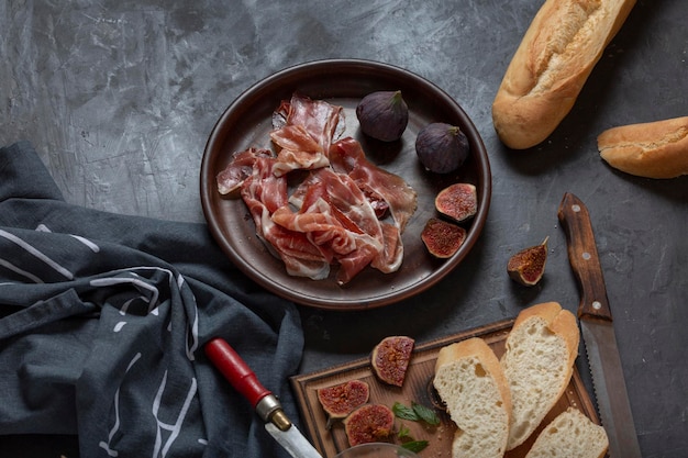 Jamon con fichi e una baguette con crema di formaggio sul tavolo da pranzo antipasto per vino cucina spagnola