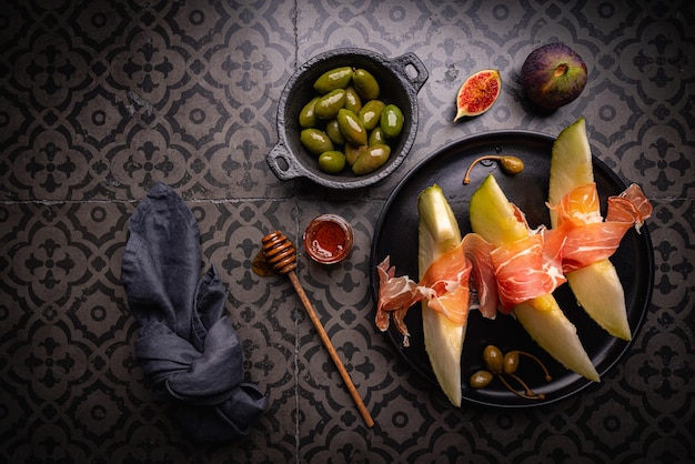 Jamon prosciutto serrano o prosciutto con melone e olive un antipasto tradizionale spagnolo e italiano