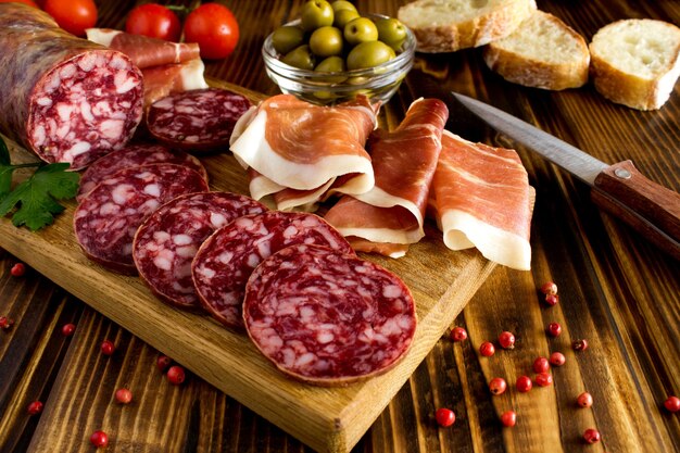 Jamon spagnolo e salsiccia nel tagliere sul legno marrone