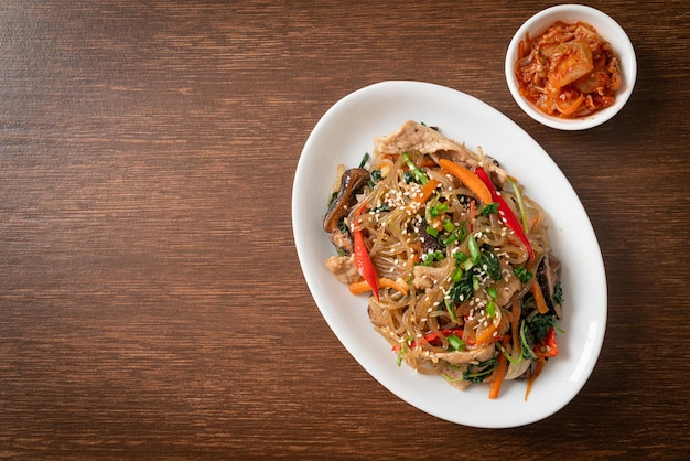 japchae o vermicelli coreani saltati in padella con verdure e maiale conditi con sesamo bianco - stile alimentare tradizionale coreano