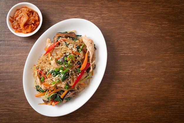 japchae o vermicelli coreani saltati in padella con verdure e maiale conditi con sesamo bianco - stile alimentare tradizionale coreano