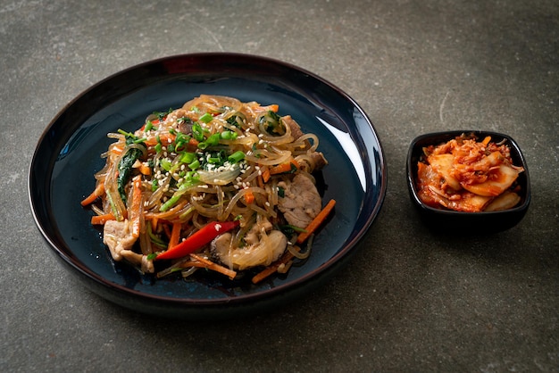 japchae o vermicelli coreani saltati in padella con verdure e maiale conditi con sesamo bianco - stile alimentare tradizionale coreano